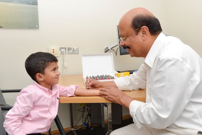 Dr Rajiv Sood performing a skin prick allergy test on a child at a London clinic